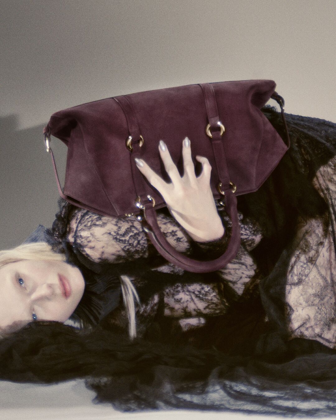 Women holding a burgundy McQueen Farringdon bag