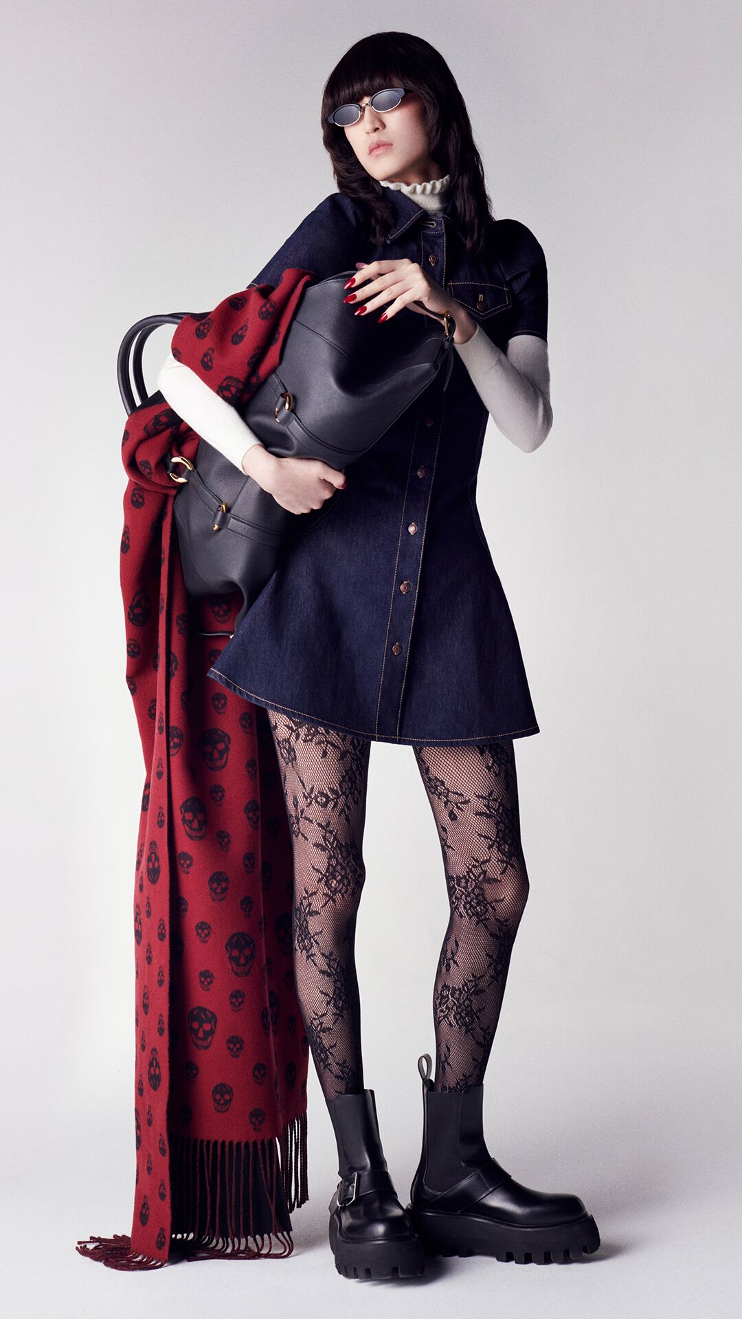 Women in a McQueen denim dress holding a Farringdon bag